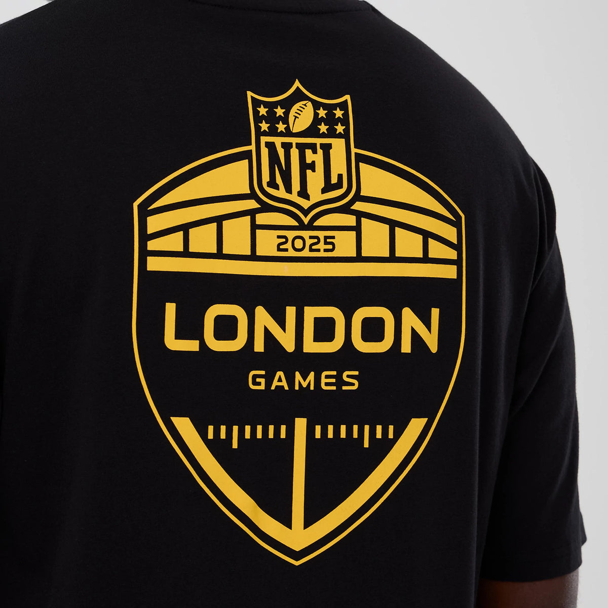 New Era Minnesota Vikings NFL International Series Games 2025 Black Oversized T-Shirt, back view showing a large printed yellow shield with NFL 2025 at the top and London Games text centred on the lower back.