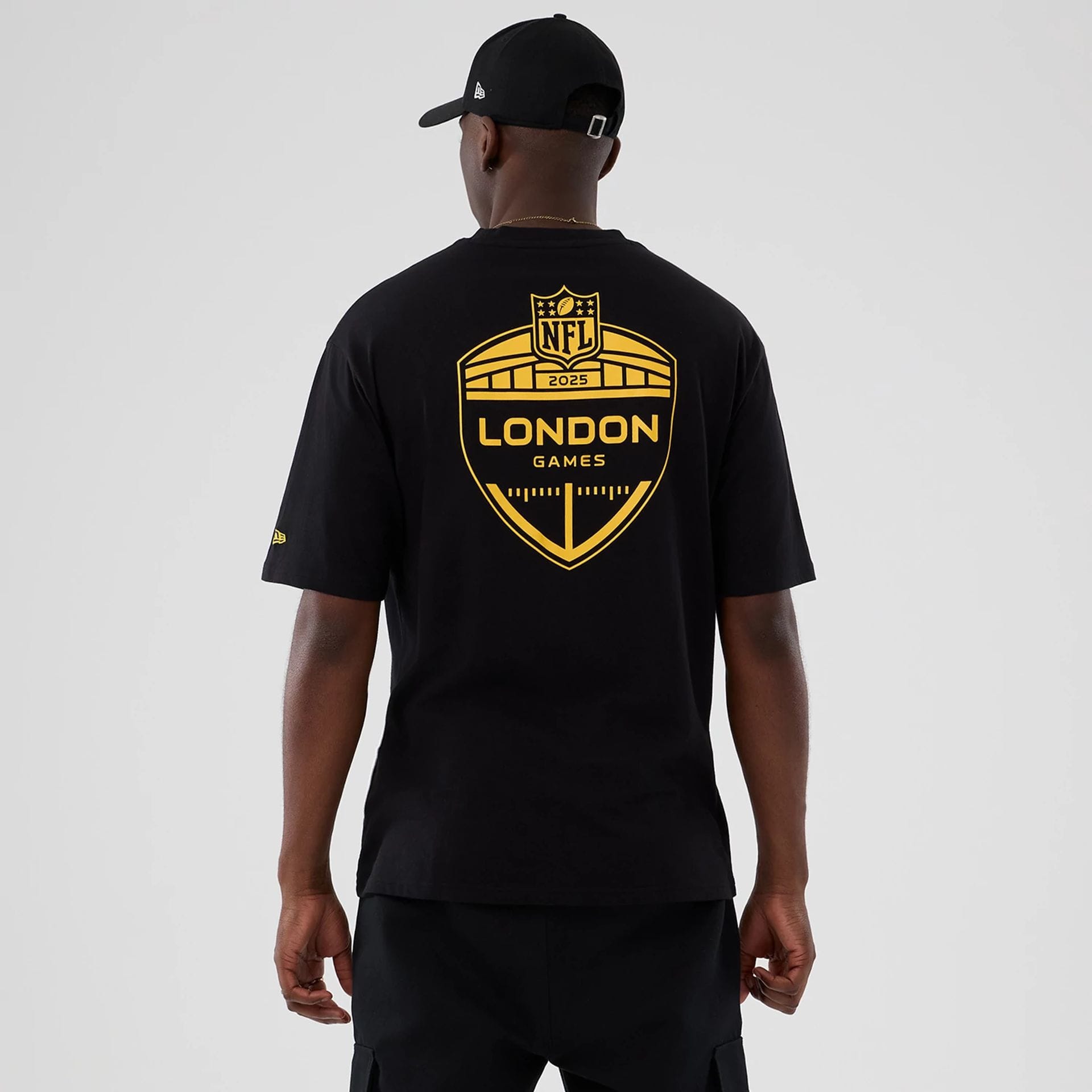 The Male model is wearing Minnesota Vikings NFL International Series Games 2025 Black Oversized T-Shirt 2