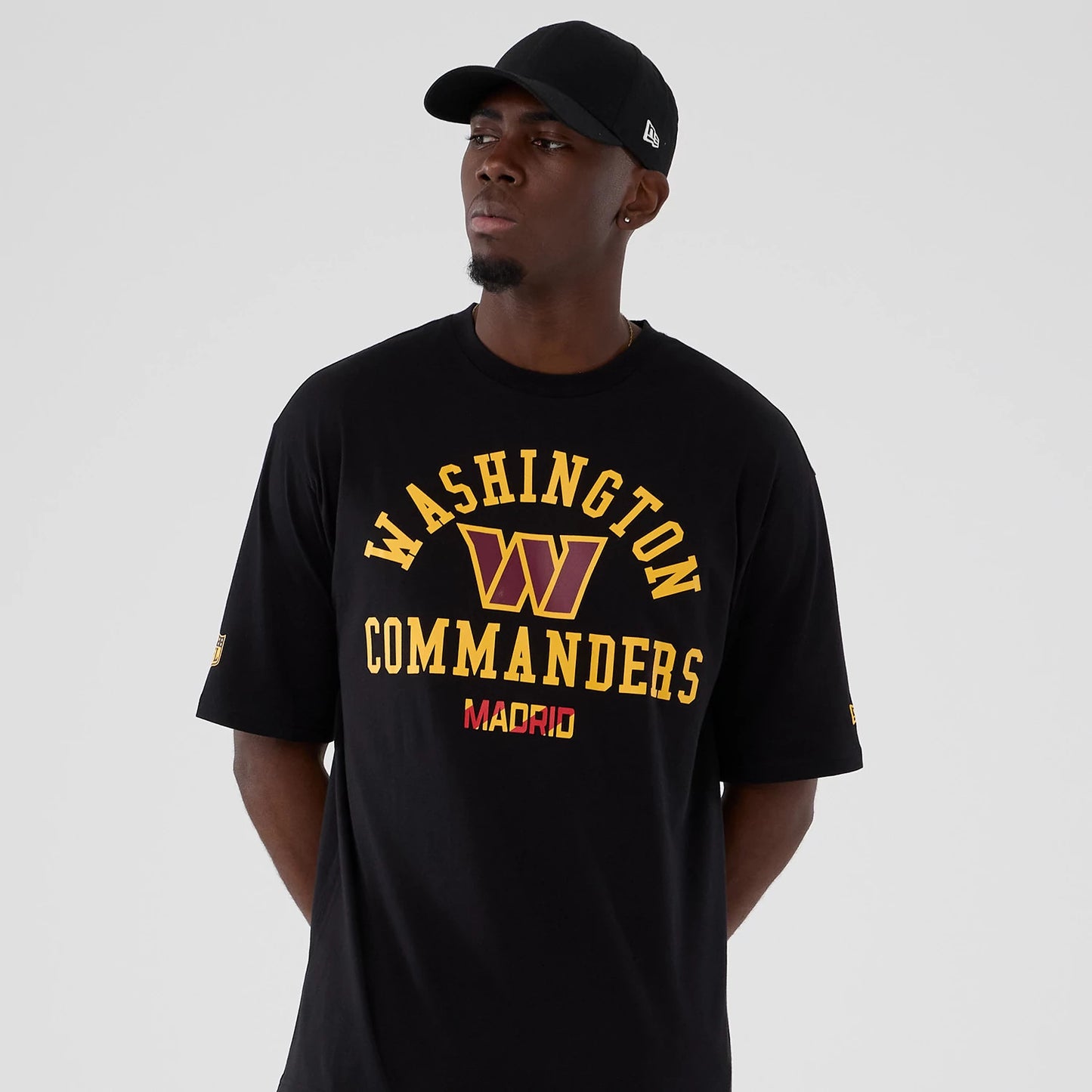 The Male model is wearing Washington Commanders NFL International Series Games 2025 Black Oversized T-Shirt 7