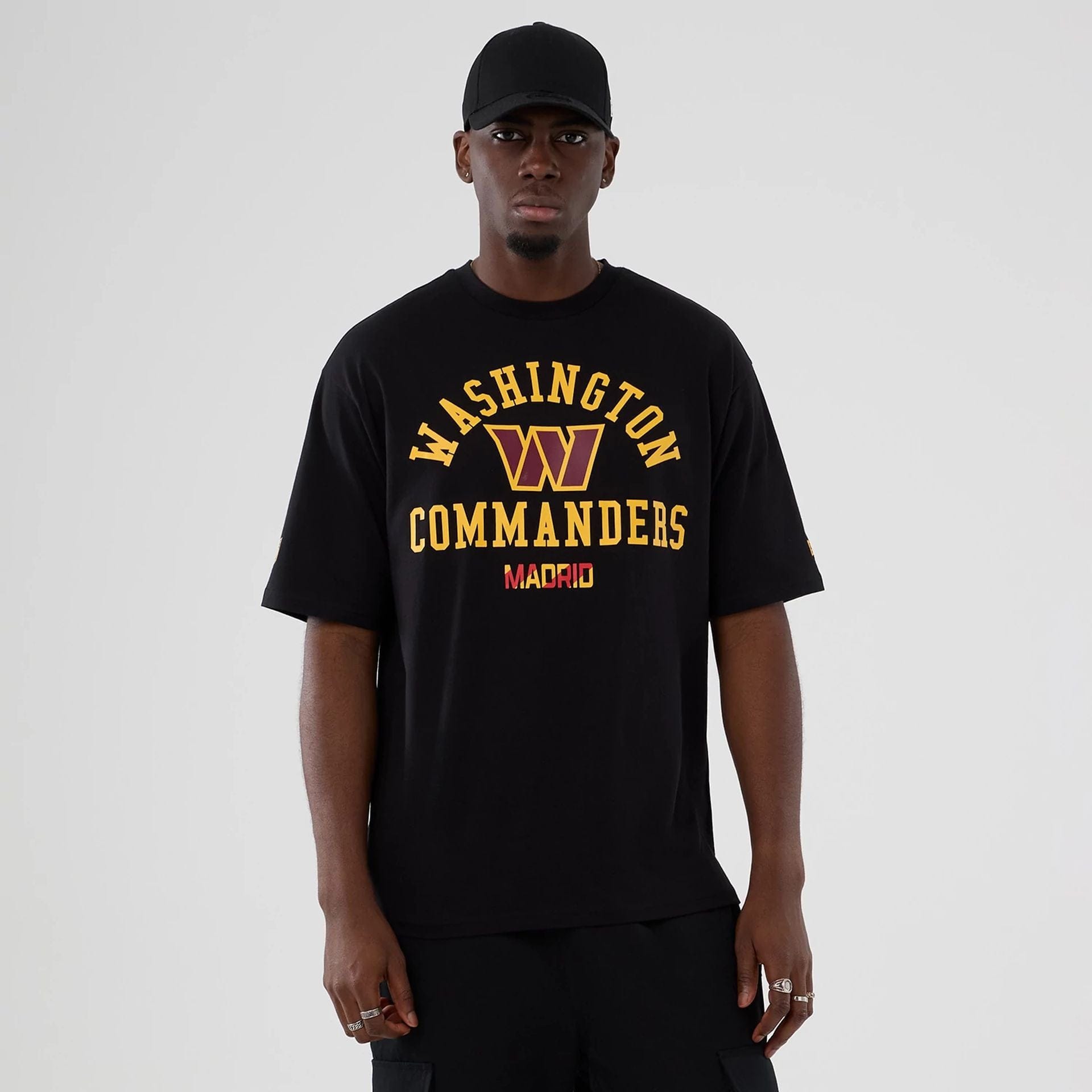 The Male model is wearing Washington Commanders NFL International Series Games 2025 Black Oversized T-Shirt 1