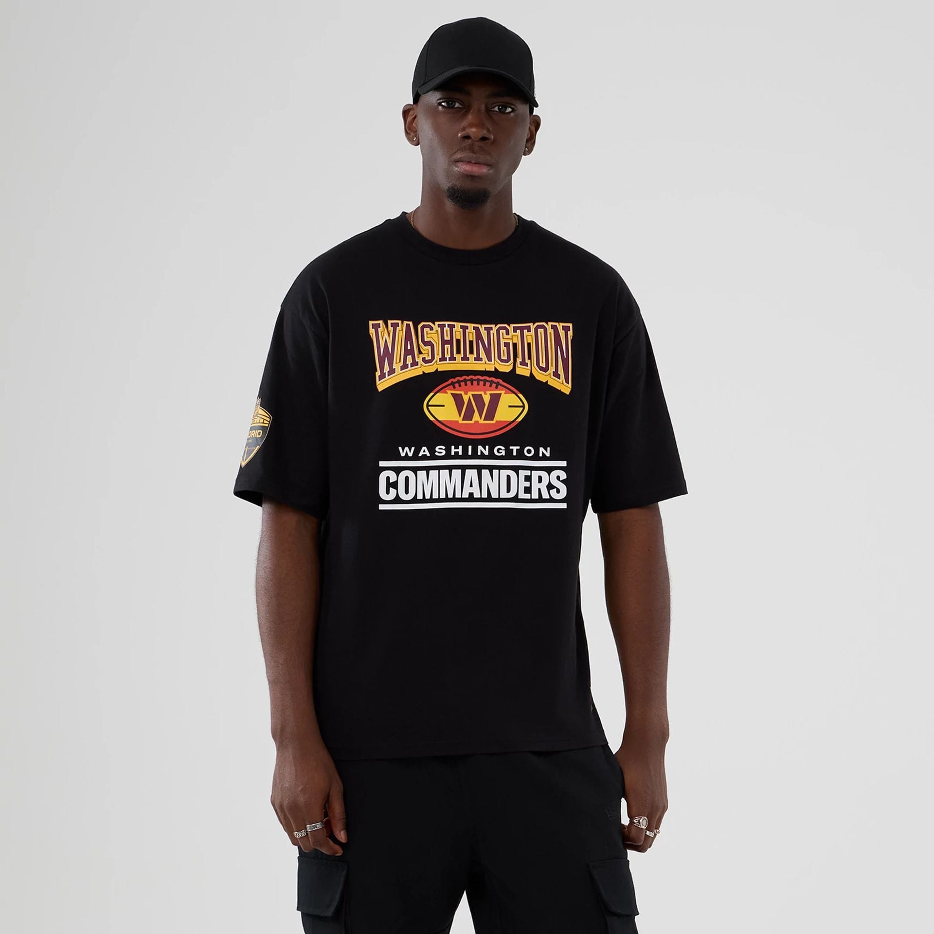 The Male model is wearing Washington Commanders NFL International Series Games 2025 Black Oversized T-Shirt 1