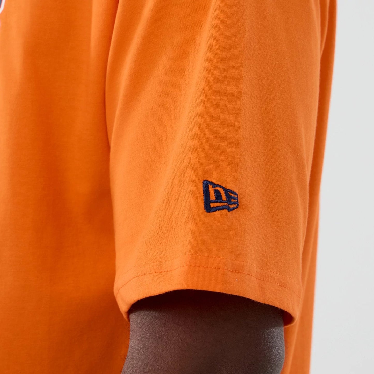 The Male model is wearing Denver Broncos NFL International Series Games 2025 Orange Oversized T-Shirt 7
