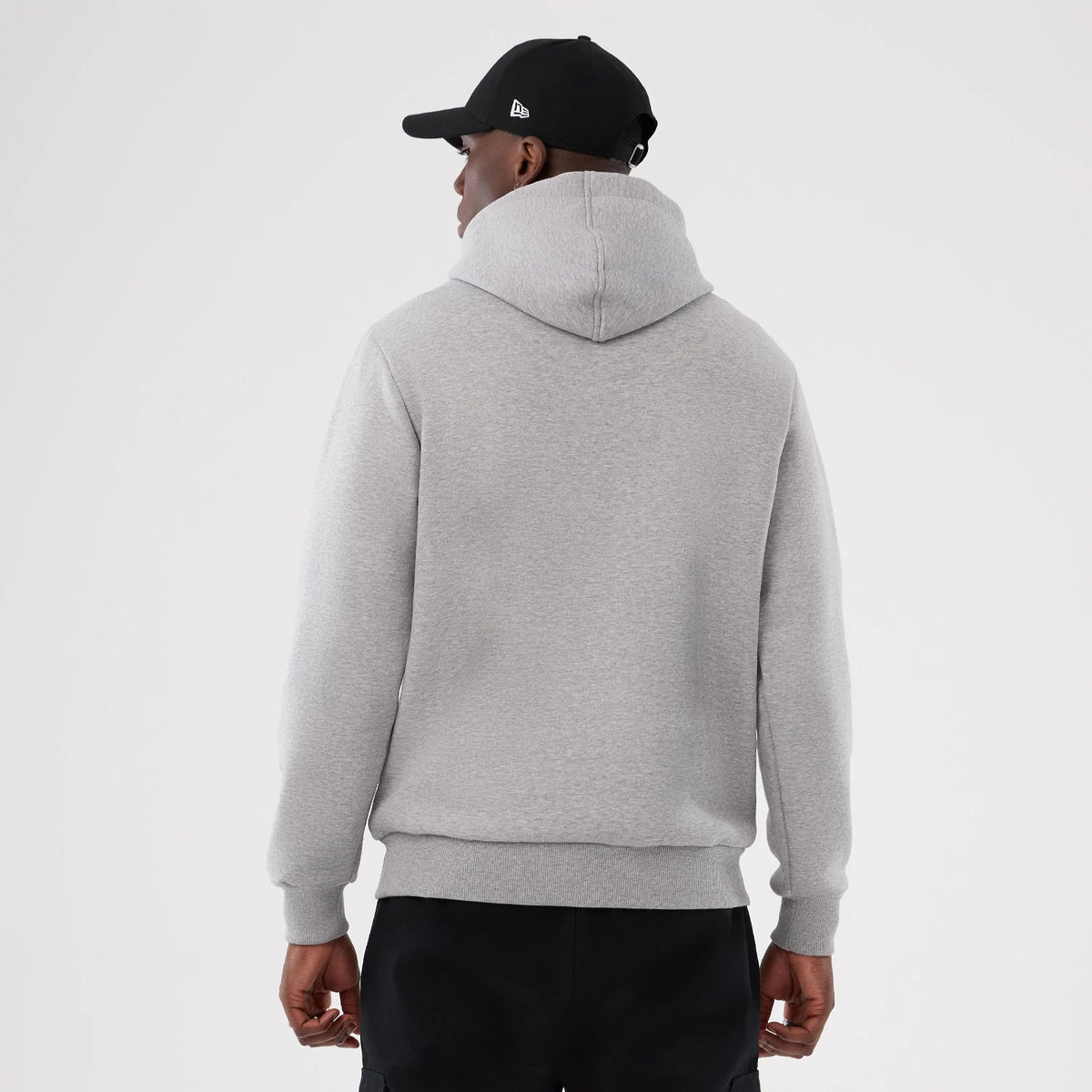 New Era Minnesota Vikings NFL International Series Games 2025 Grey Pullover Hoodie, back view on a model in dark trousers showing the plain grey back with a relaxed fit and ribbed cuffs, featuring a snug hood and no logos.