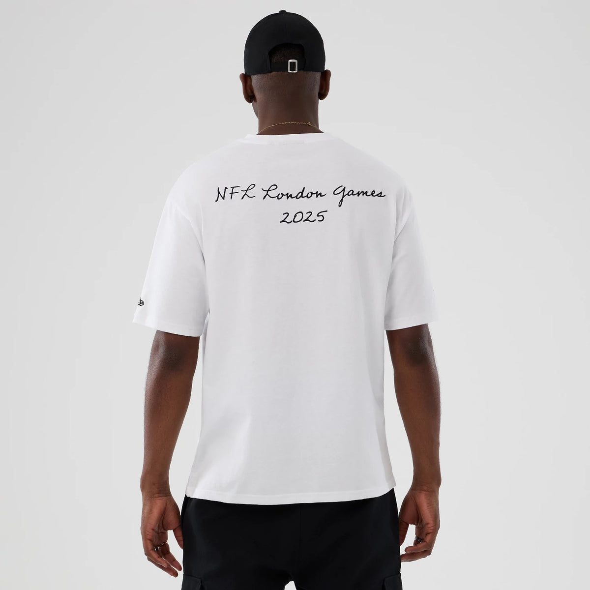 New Era LA Rams NFL International Series Games 2025 White Premium T-Shirt, back view on-model featuring NFL London Games 2025 in black script across the upper back and a small embroidered New Era logo on the left sleeve.