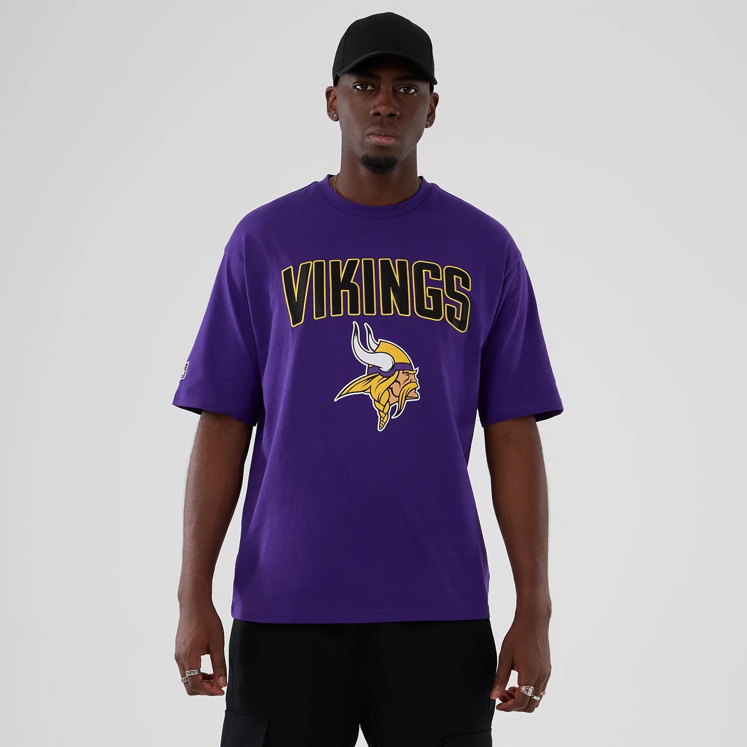 The Male model is wearing Minnesota Vikings NFL International Series Games 2025 Purple Premium T-Shirt 1