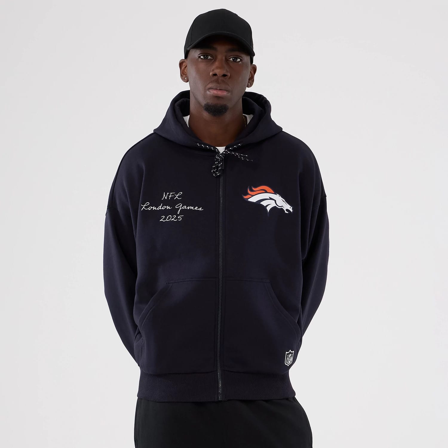 The Male model is wearing Denver Broncos NFL International Series Games 2025 Navy Premium Pullover Hoodie 1