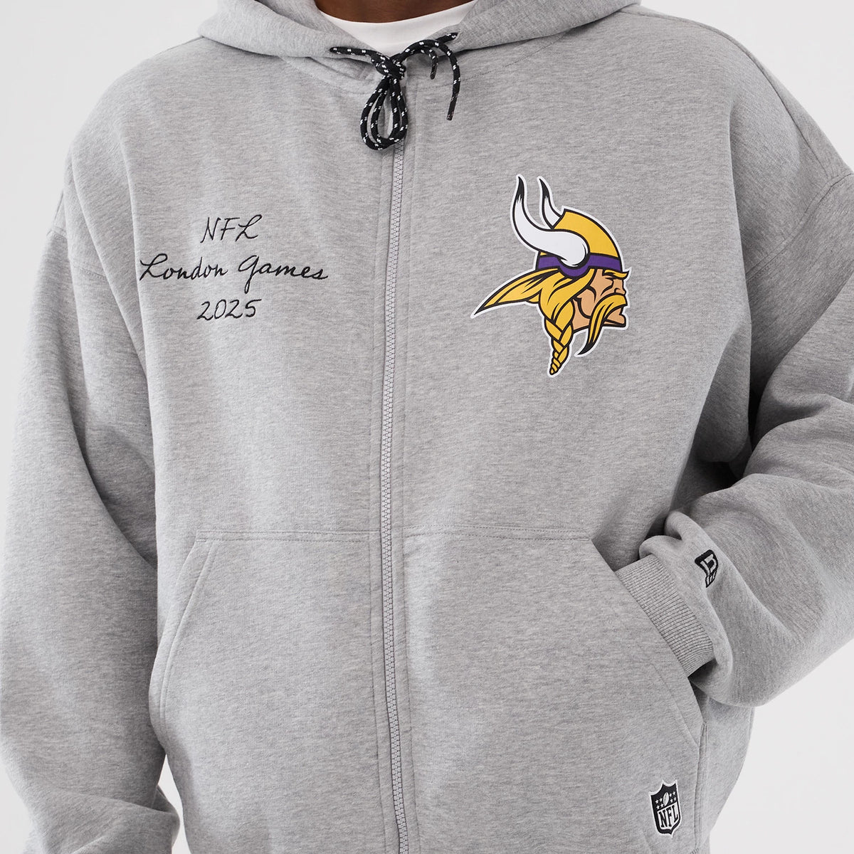 New Era Minnesota Vikings NFL International Series Games 2025 Grey Premium Pullover Hoodie, front view with a large printed Vikings logo on the chest, embroidered NFL London Games 2025 text on the left.