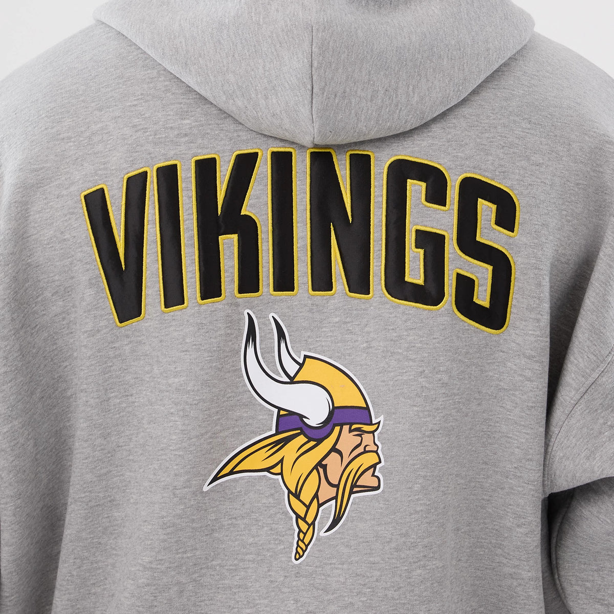 New Era Minnesota Vikings NFL International Series Games 2025 Grey Premium Pullover Hoodie, back view showing large black VIKINGS lettering outlined in yellow across the upper back and a printed Vikings logo below on the light grey fabric.