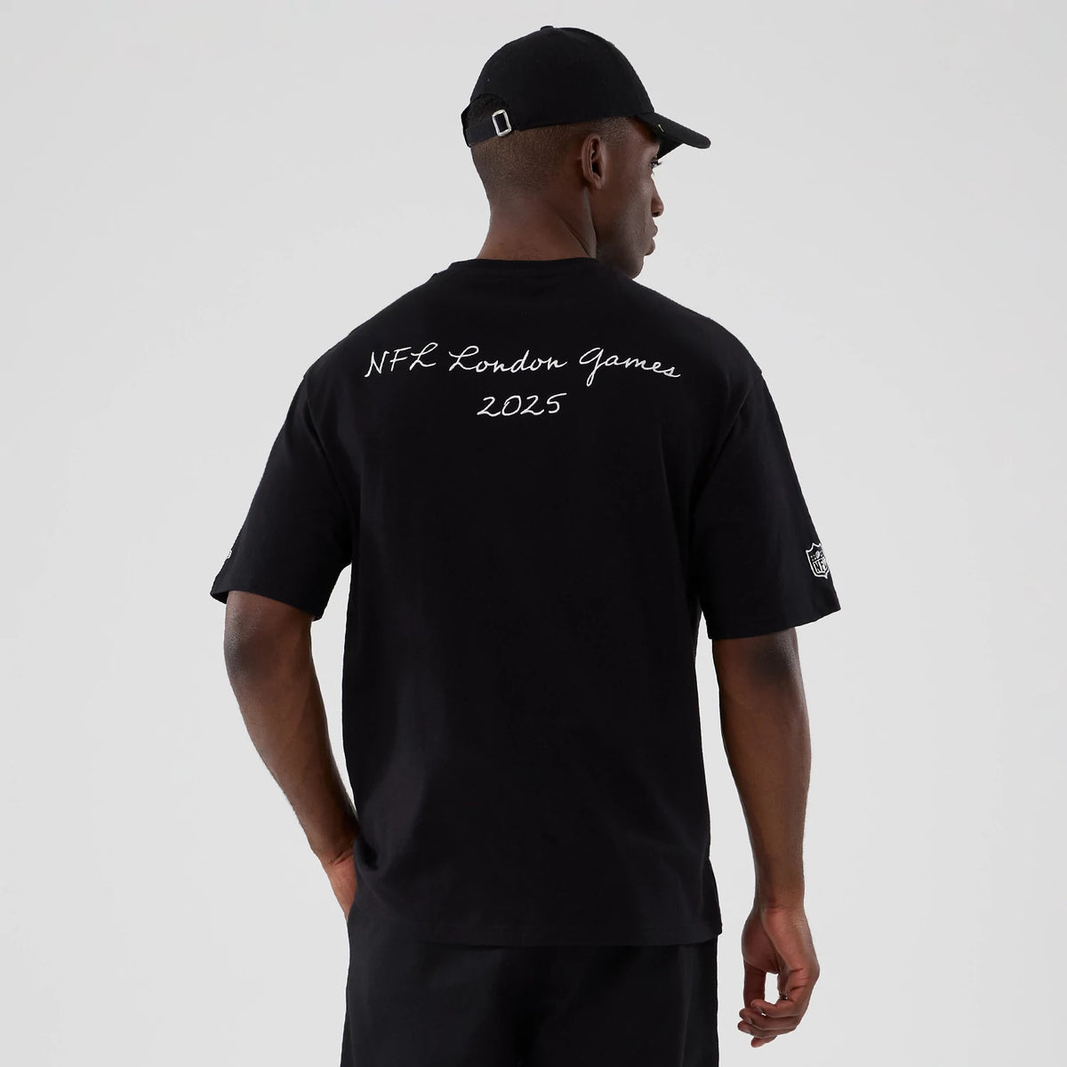 New Era Minnesota Vikings NFL International Series Games 2025 Black Premium T-Shirt, back view on a model with a black cap, showing white embroidered text reading NFL London Games 2025 across the upper back and a logo on the left sleeve.