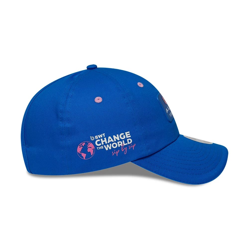 New Era Alpine Racing Womens Team Blue Pony Tail Cap, side view with a structured blue crown featuring a Change the World graphic embroidery in pink and white and an Alpine logo label on the visor.