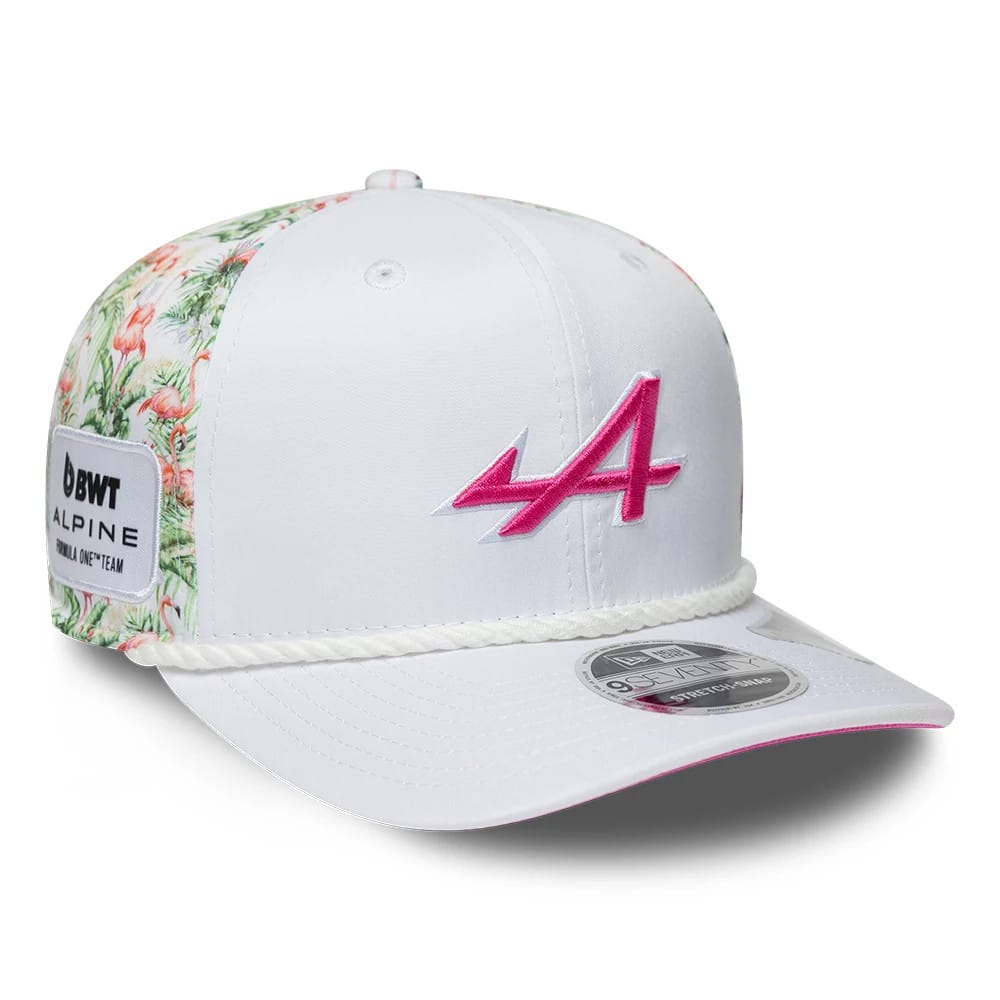 Alpine Racing Miami Race Special White New Era 9SEVENTY Stretch Snap Adjustable Cap, three-quarter view showing the pink A logo on the front panel, the floral patterned side panels, and a 9SEVENTY size sticker on the white visor.