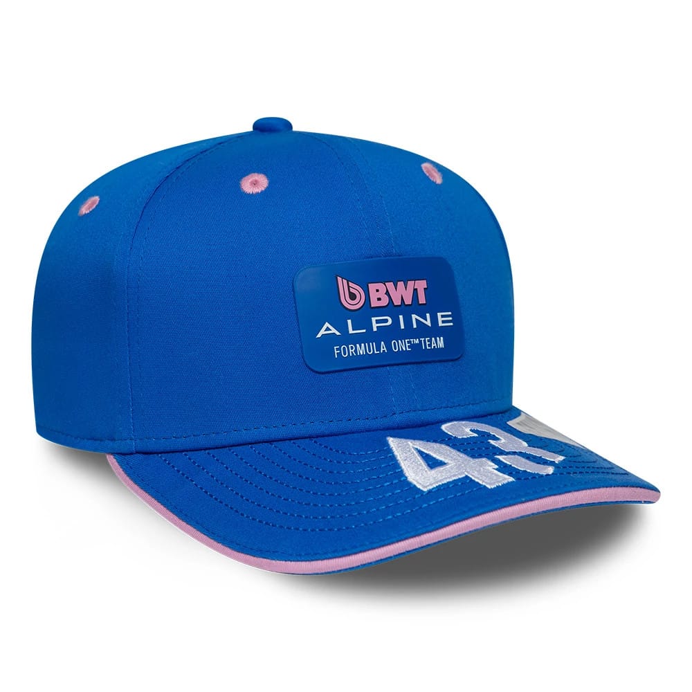 Alpine Racing Franco Colapinto Blue New Era 9SEVENTY Stretch Snap Adjustable Cap, three-quarter view showing a blue patch with pink BWT Alpine Formula One Team branding on the front panel and large white 43 embroidery on the blue visor edged in pink.