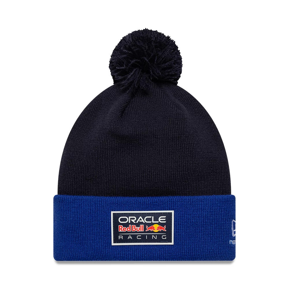 New Era Red Bull Racing Essential Dark Blue Bobble Knit Beanie Hat, front view showing the embroidered Oracle Red Bull Racing logo patch on the blue cuff, with a dark blue bobble on top and the New Era flag logo on the side.