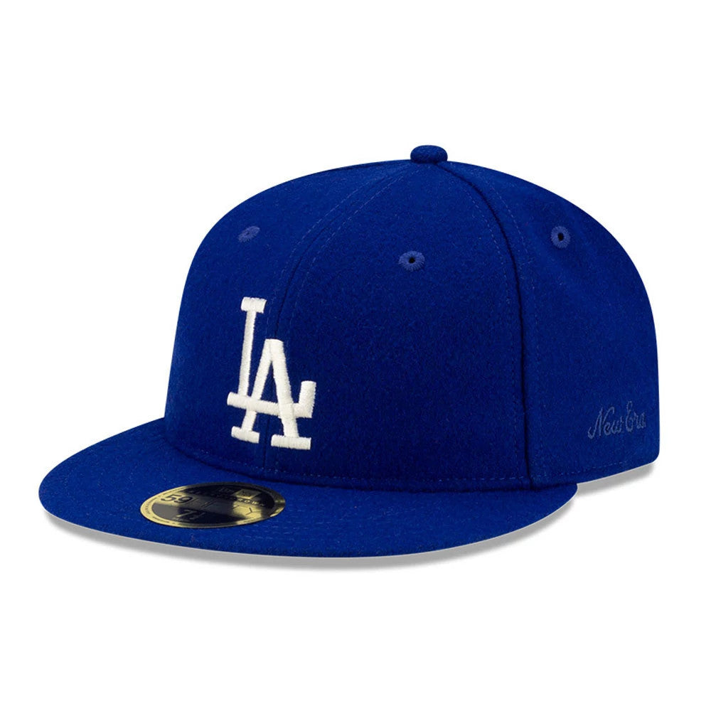 LA Dodgers FOG X MLB Dark Blue Retro Crown New Era 59FIFTY Fitted Cap, three-quarter view showing the white raised LA logo on the front panel, a dark blue flat visor with gold 59FIFTY size sticker, and New Era script on the left side.