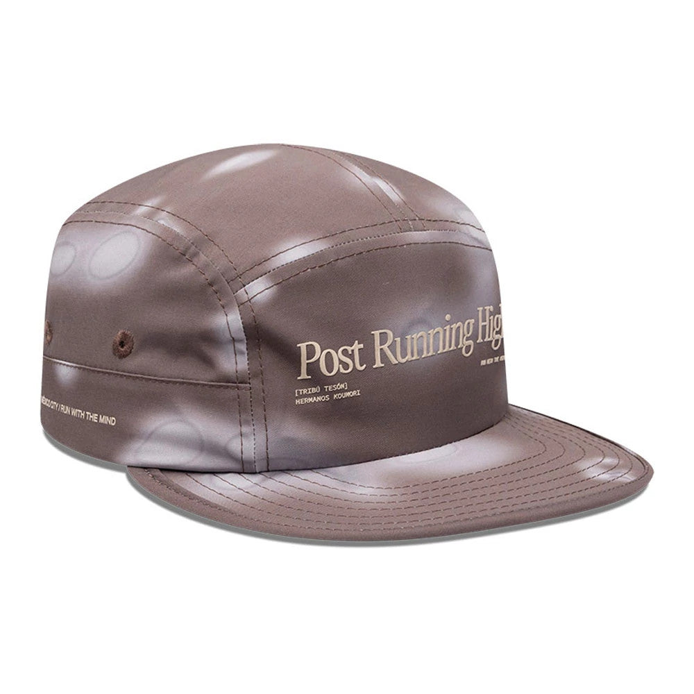 Hermanos Koumori x New Era Dark Brown Camper Cap, three-quarter view showing Post Running High printed in cream on the front panel, with coordinating cream stitching on the structured dark brown visor.