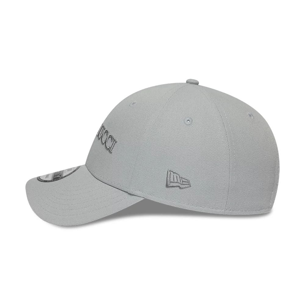 Colucci X New Era Grey 9FORTY Adjustable Cap, side view showing the grey embroidered Colucci logo on the front panel, New Era flag logo on the left side, curved visor with 9FORTY size sticker, and matching top button.