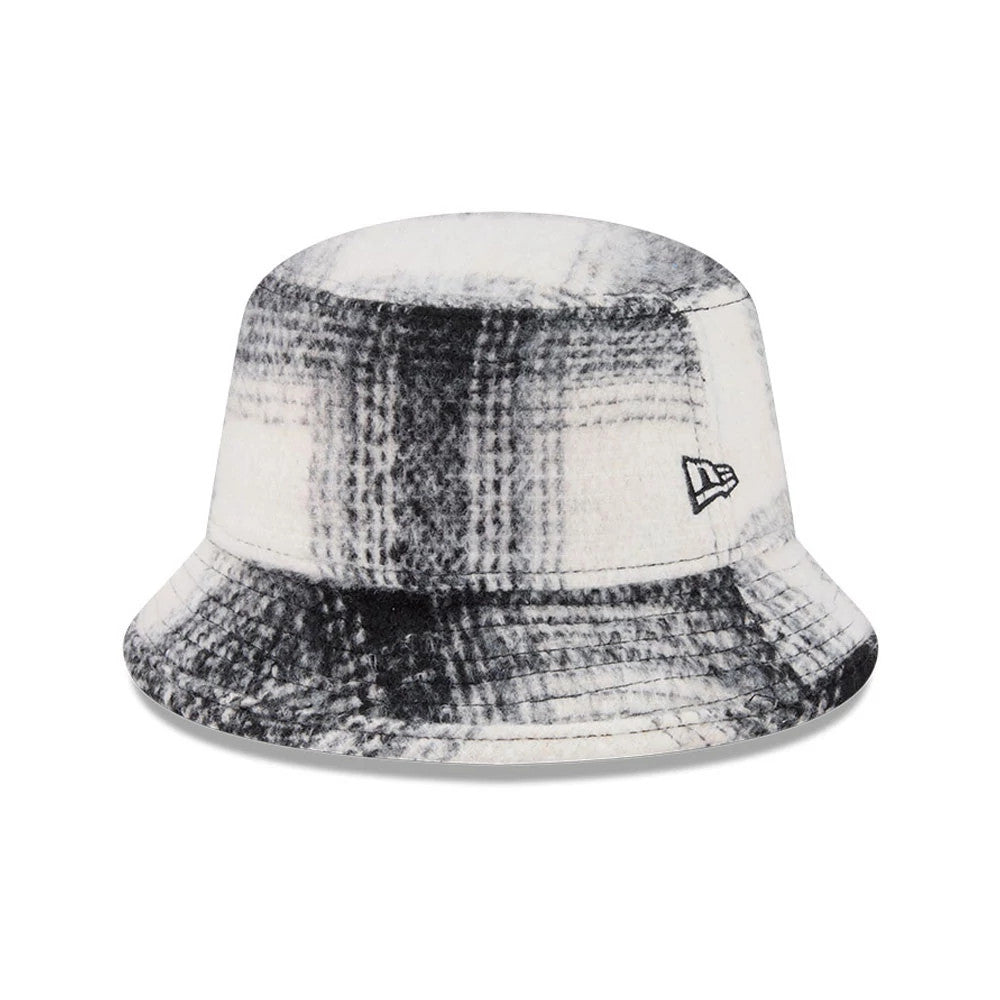 New Era White & Black Plaid Bucket Hat, three-quarter view showing the black embroidered New Era flag logo on the right side, featuring a soft crown and wide visor with a distinctive plaid pattern in white and black tones.