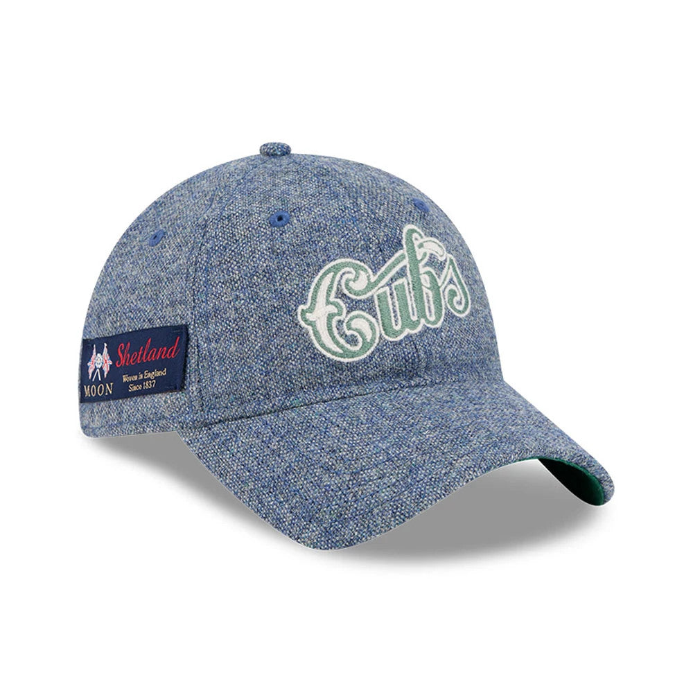 Chicago Cubs MLB X Moon Blue New Era 9TWENTY Adjustable Cap, three-quarter view showing the white and green embroidered Cubs script logo on the blue textured fabric, with a Moon Shetland patch on the left side and a green undervisor.