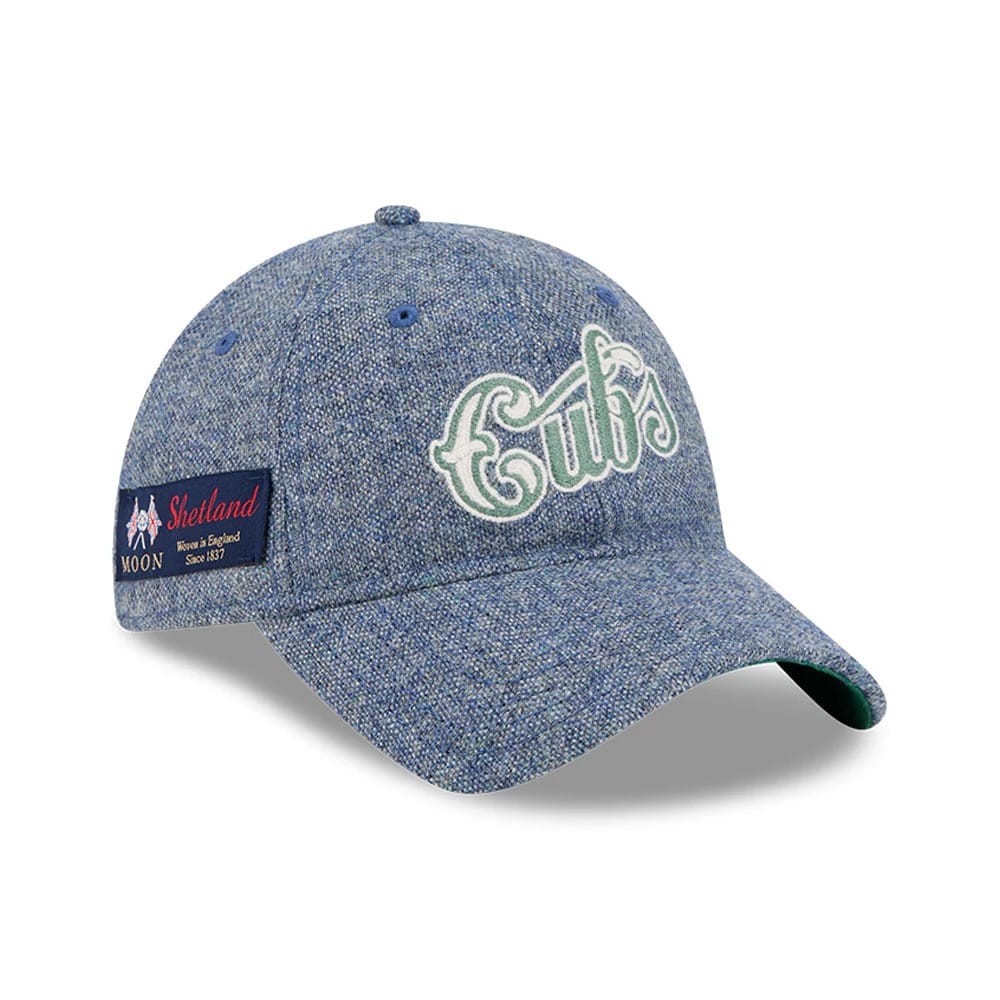 Chicago Cubs MLB X Moon Blue New Era 9TWENTY Adjustable Cap, three-quarter view showing the white and green embroidered Cubs script logo on the blue textured fabric, with a Moon Shetland patch on the left side and a green undervisor.