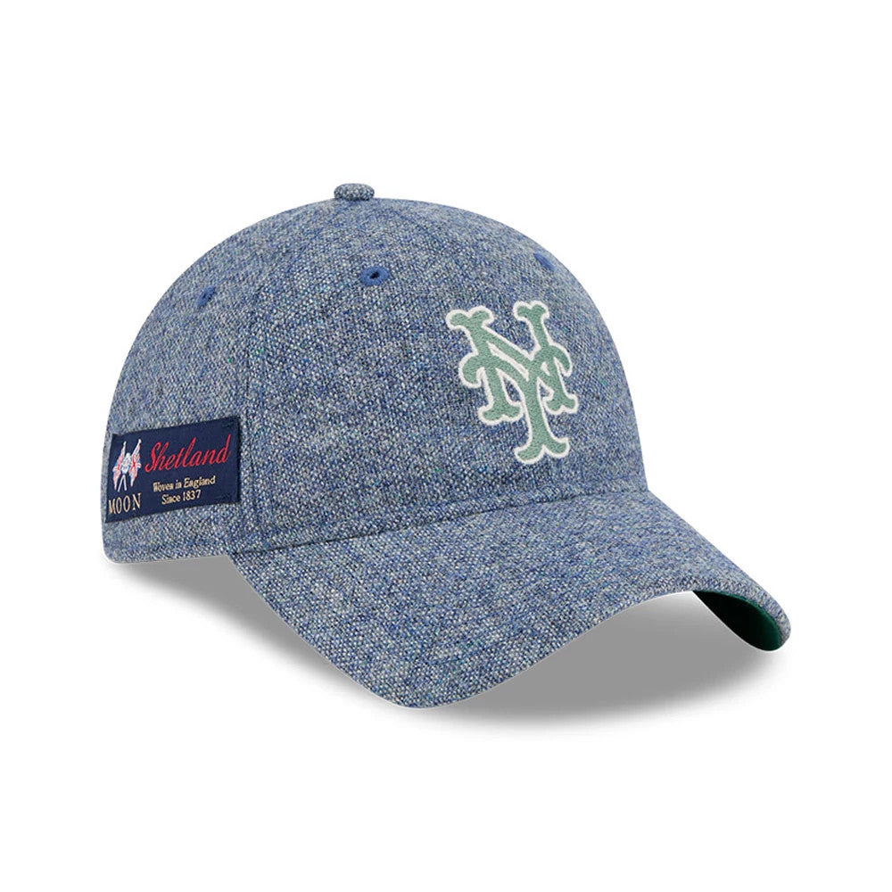 New York Mets MLB X Moon Blue New Era 9TWENTY Adjustable Cap, three-quarter view showing raised mint green embroidered NY logo on the front panel, curved blue visor and woven Moon Shetland patch on the right side.