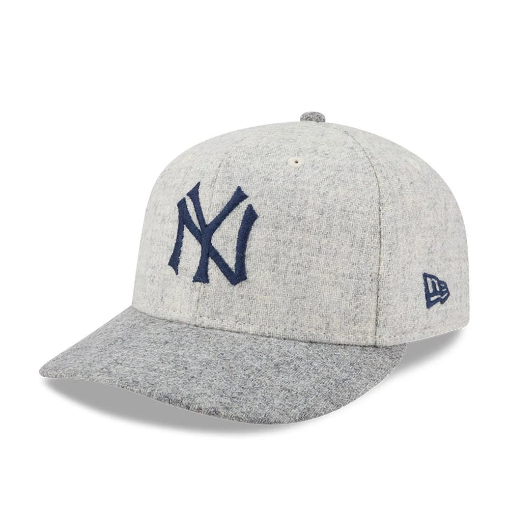 New York Yankees MLB X Moon Light Beige New Era 59FIFTY Fitted Cap, three-quarter view showing the navy NY logo in raised embroidery on the light beige front panels, with a grey heathered visor and New Era flag logo on the left side.