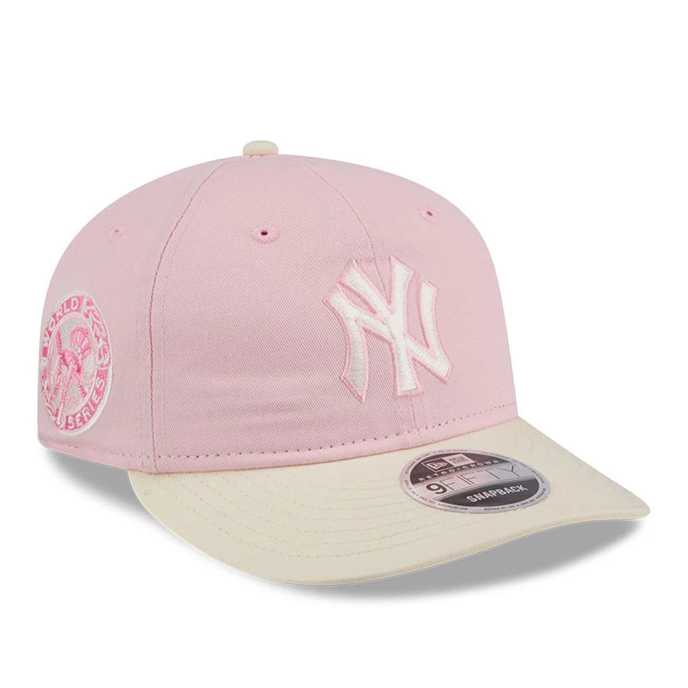 New York Yankees MLB Washed Tie Dye Pastel Pink New Era 9FIFTY Snapback Adjustable Cap, three-quarter view showing the white embroidered NY logo on the front panel, cream flat visor with a 9FIFTY size sticker, and side World Series logo.