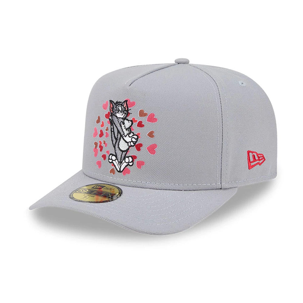 Tom & Jerry Love Struck Grey New Era 59FIFTY A-Frame Fitted Cap, three-quarter view showing Tom embraced by embroidered pink and brown hearts on the front panel, curved grey visor with gold 59FIFTY size sticker.