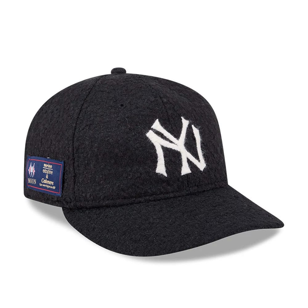 New York Yankees MLB X Moon Navy Retro Crown New Era 9FIFTY Adjustable Cap, three-quarter view showing the white raised-embroidered NY logo on the front panel, a navy visor, and a merino, cashmere and lambswool fabric label on the left side.