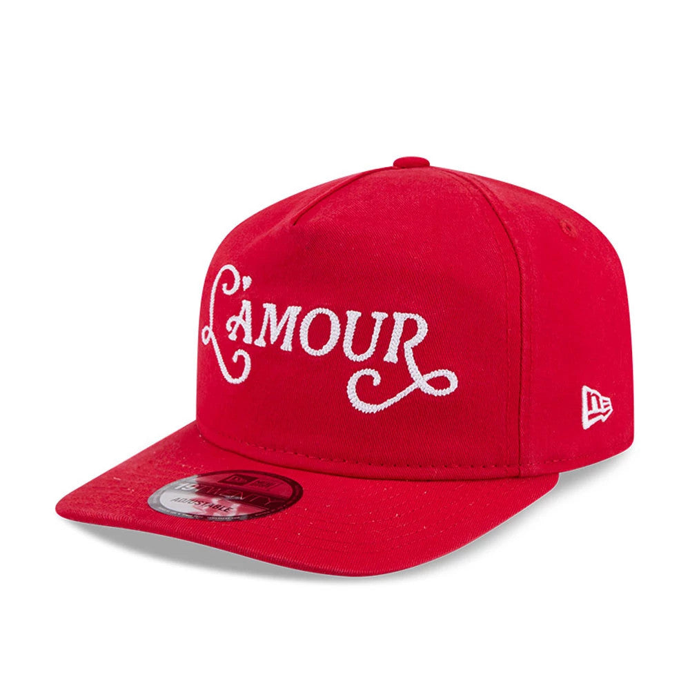 New Era L'amour Red New Era 19TWENTY Adjustable Cap, three-quarter view showing the white embroidered L'amour text across the front panel, with a flat red visor featuring a 19TWENTY size sticker and the New Era flag logo on the left side.