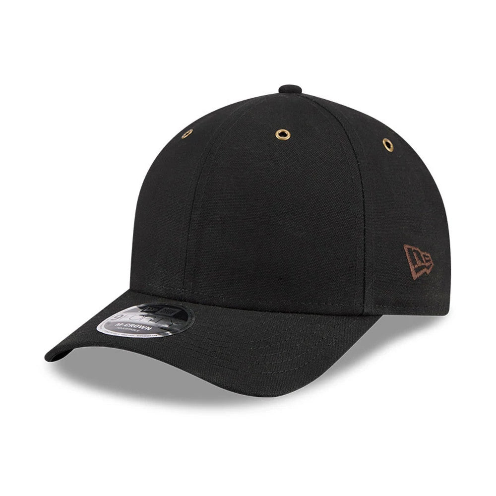 New Era Premium Black New Era 9FORTY M-Crown Adjustable Cap, three-quarter view showing the brown embroidered New Era flag logo on the left side, black curved visor with a 9FORTY size sticker, and gold eyelets on the crown.