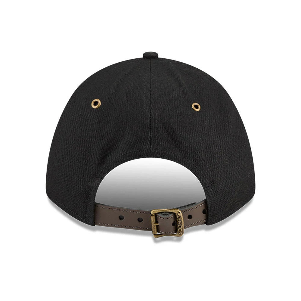 New Era Premium Black 9FORTY M-Crown Adjustable Cap, rear view showing gold eyelets on the black structured crown, a brown adjustable strap with a buckle, and New Era branding etched into the buckle near the centre.