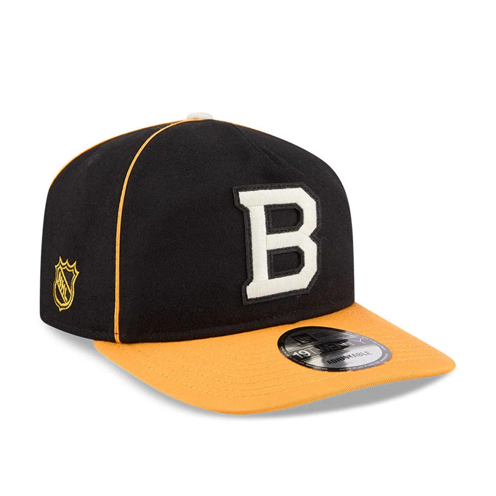 Boston Bruins NHL Felt Logo Black New Era 19TWENTY Adjustable Cap, three-quarter view showing a large white felt B embroidered on the front of the black crown, an orange visor with a 19TWENTY size sticker, and an NHL shield on the left side.