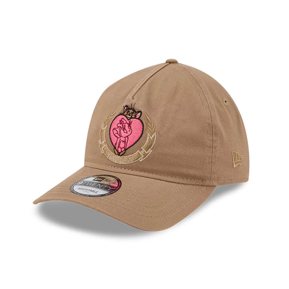 Tom & Jerry True Love Beige New Era 9TWENTY A-Frame Adjustable Cap, three-quarter view showing pink and brown embroidered Tom & Jerry graphic on the front panel, matching beige eyelets and crown, and a 9TWENTY size sticker on the curved visor.