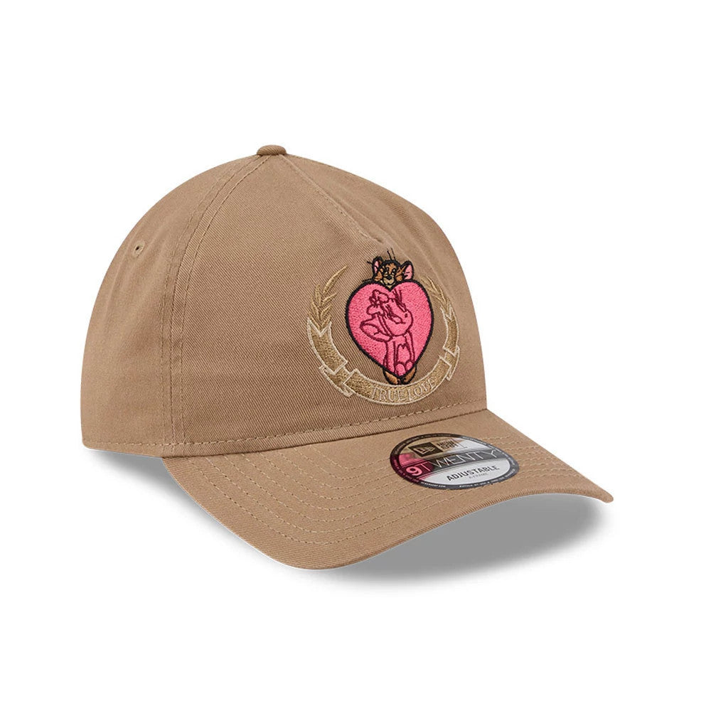 Tom & Jerry True Love Beige New Era 9TWENTY A-Frame Adjustable Cap, three-quarter view showing the pink embroidered heart graphic with Tom and Jerry on the front panel, curved visor with a 9TWENTY size sticker, and classic six-panel design.