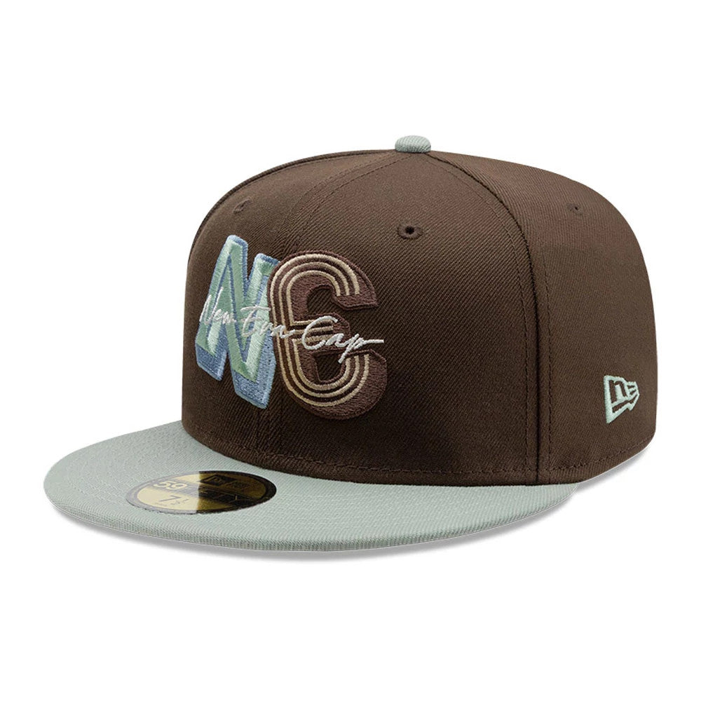 New Era DIY Note Dark Brown 59FIFTY Fitted Cap, three-quarter view showing the large embroidered NC logo in blue and brown on the front panel, contrasting light green visor with a gold 59FIFTY size sticker, and New Era flag logo on the left side.