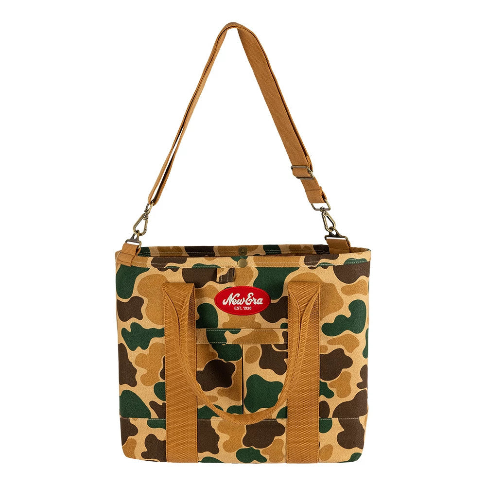 New Era Duck Camo Tote Bag, front view featuring a duck camo pattern in shades of brown and green, two brown handles around a front pocket, and a red embroidered New Era logo placed prominently near the top centre.