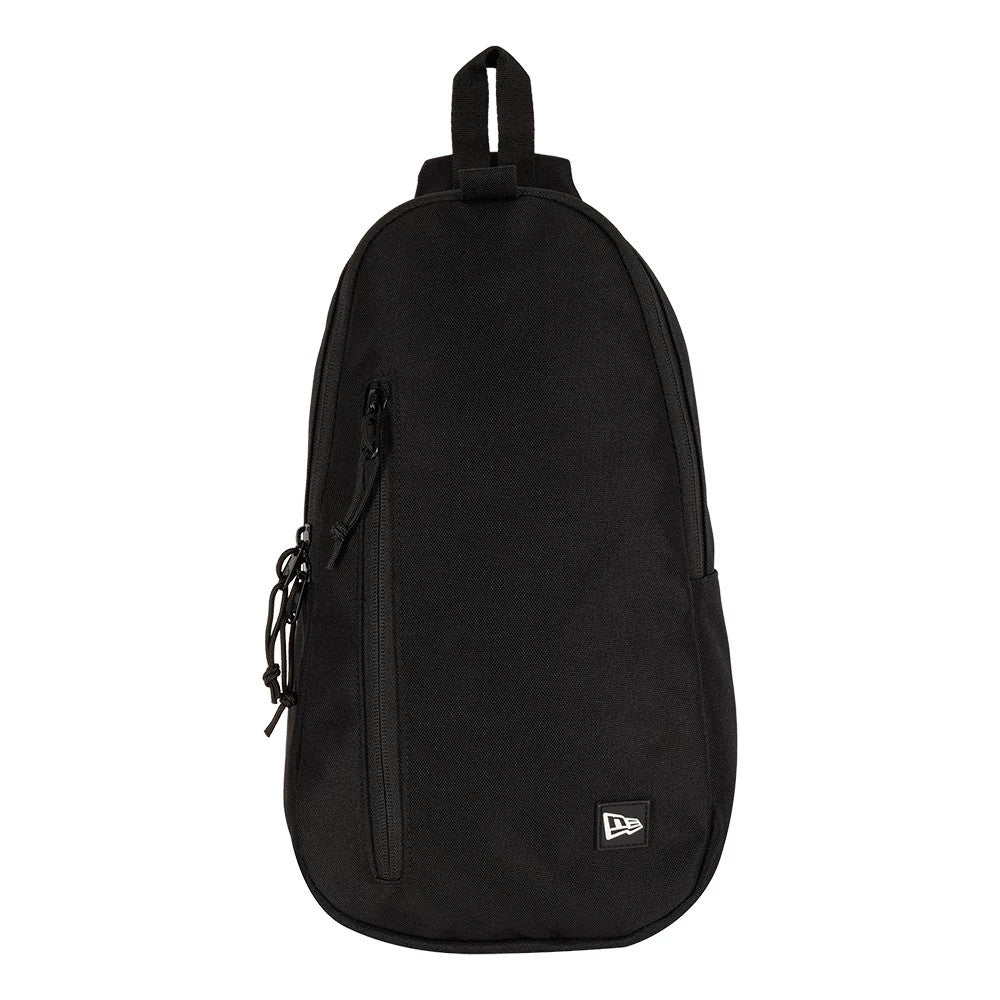 New Era Black Cross Body Sling Bag, front view highlighting the black surface, a vertical zip pocket on the left side, and a small embroidered New Era logo at the bottom right corner of the bag.