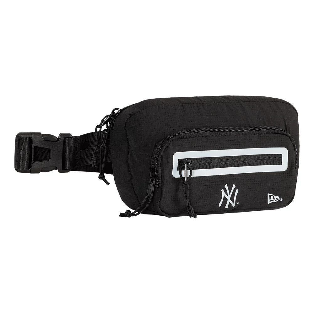 New Era New York Yankees MLB Active Mesh Black Waist Bag, side view showcasing a black body with a front zip pocket, a reflective horizontal stripe, and white embroidered Yankees logo alongside a New Era logo near the base.