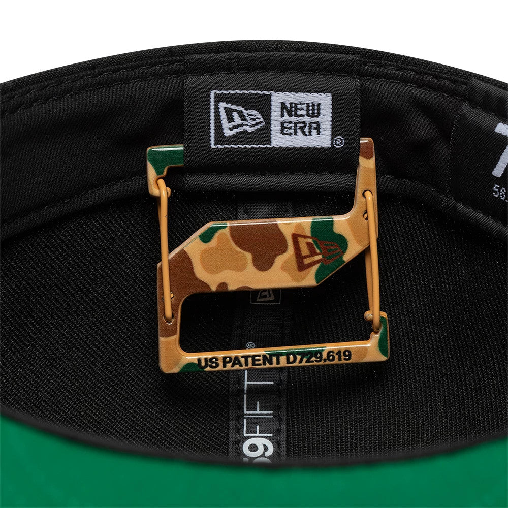 New Era Duck Camo Cap Clip, inside view showing the camo-patterned clip with the New Era flag logo, attached to the black interior with a patent number, alongside a black sweatband and green undervisor.
