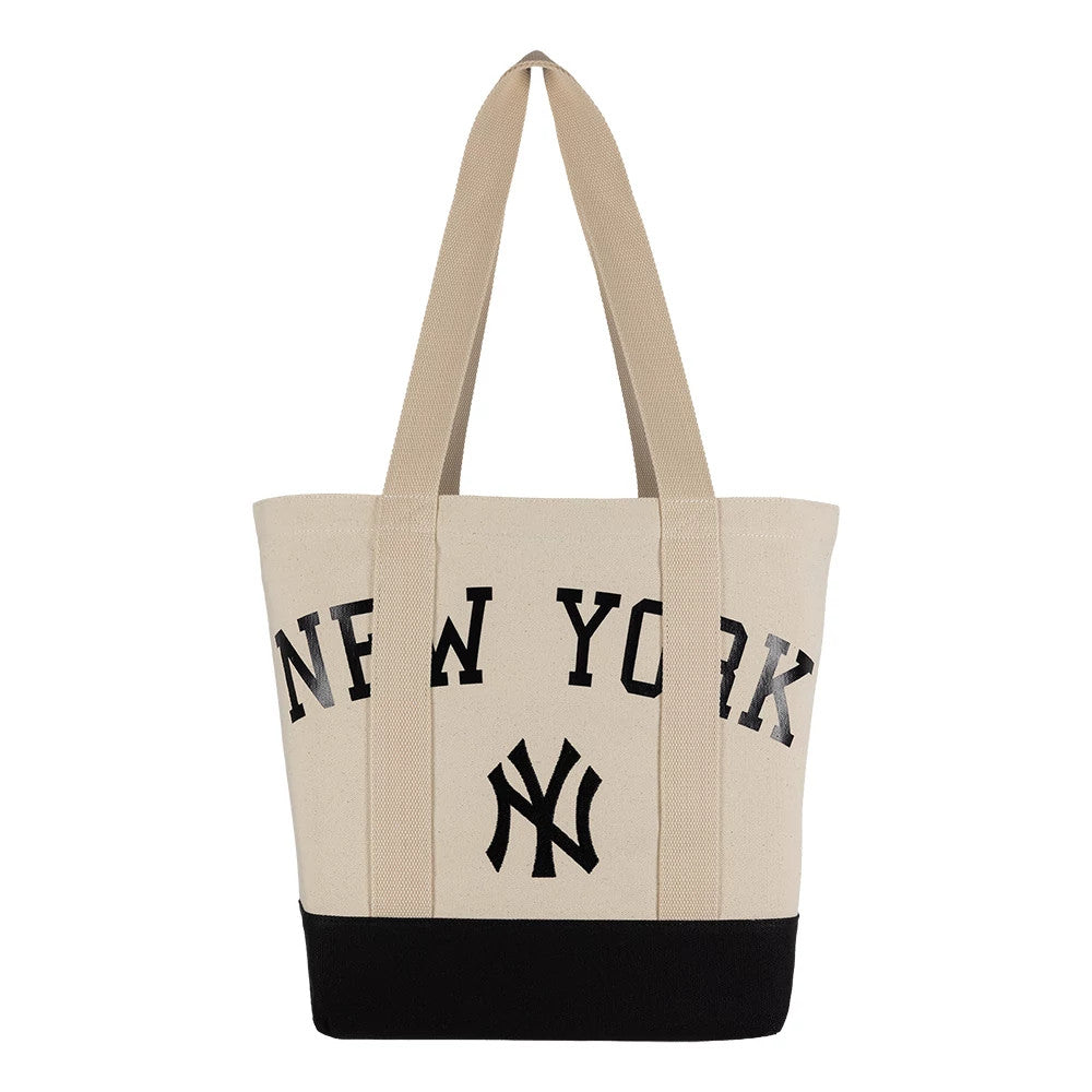 New Era New York Yankees MLB Script Light Beige Tote Bag, front view showing the black embroidered New York script across the upper section, the Yankees logo centred below, and contrasting black base and twin carry handles extending upwards.