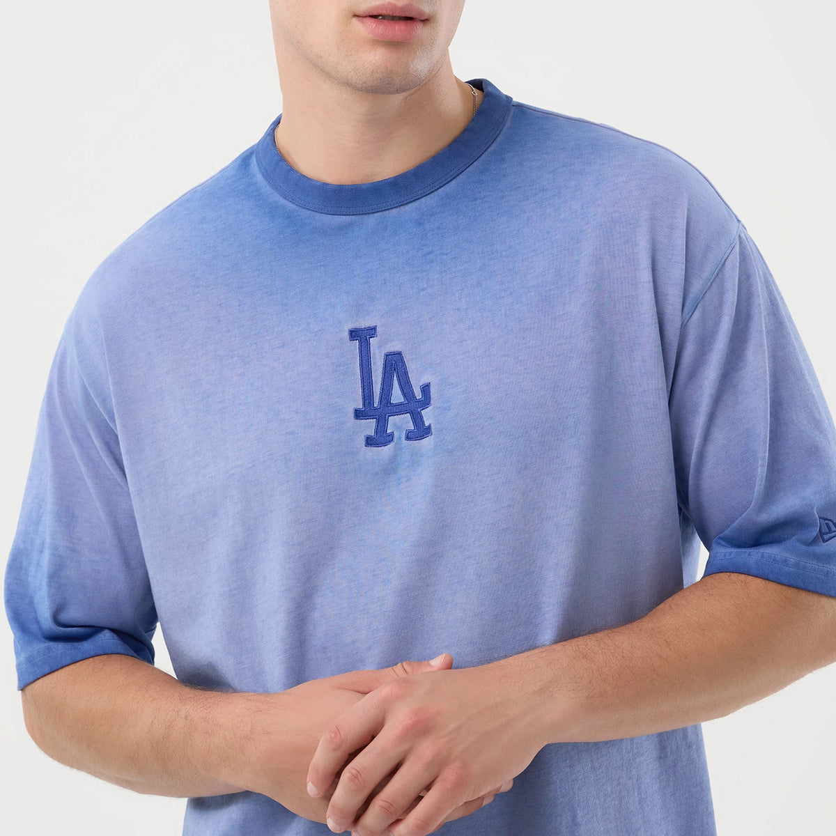 New Era LA Dodgers MLB Washed Logo Pastel Blue T-Shirt, front view on-model showcasing the gradient blue hue, short sleeves and large embroidered LA Dodgers logo at the centre of the chest, with a small New Era logo embroidered on the left sleeve.