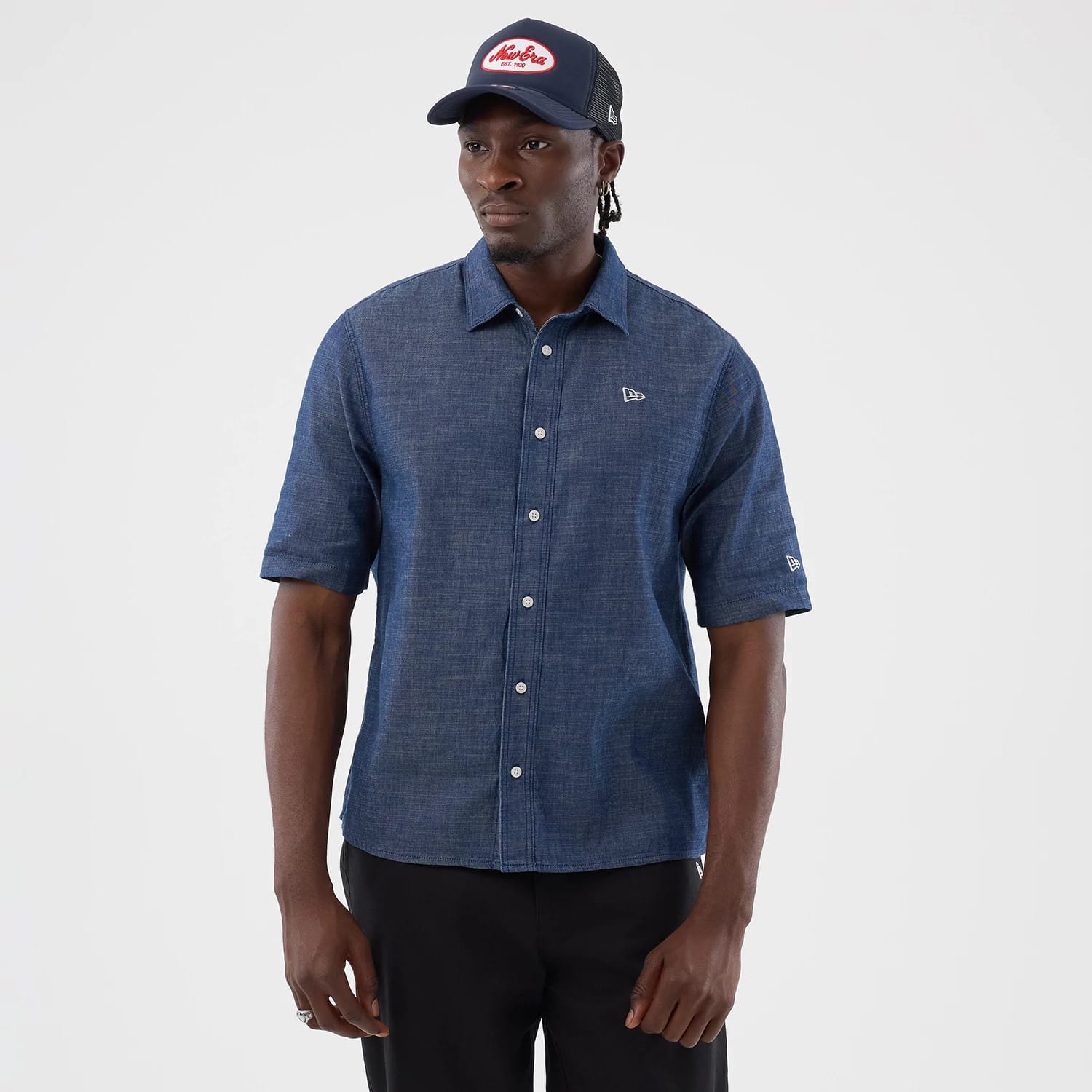 The model is wearing this New Era Denim Short Sleeve Shirt in blue. 1