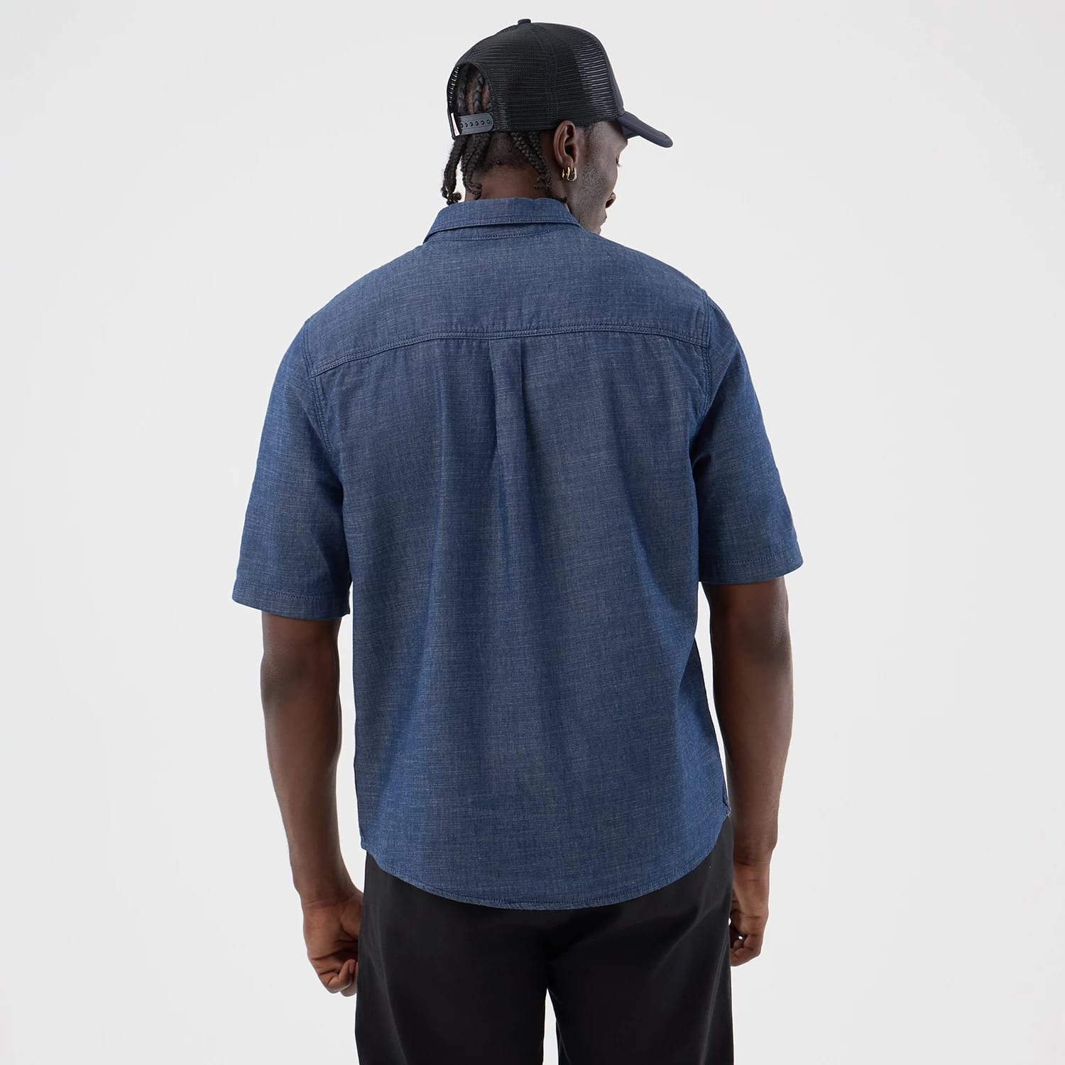 The model is wearing this New Era Denim Short Sleeve Shirt in blue. 2