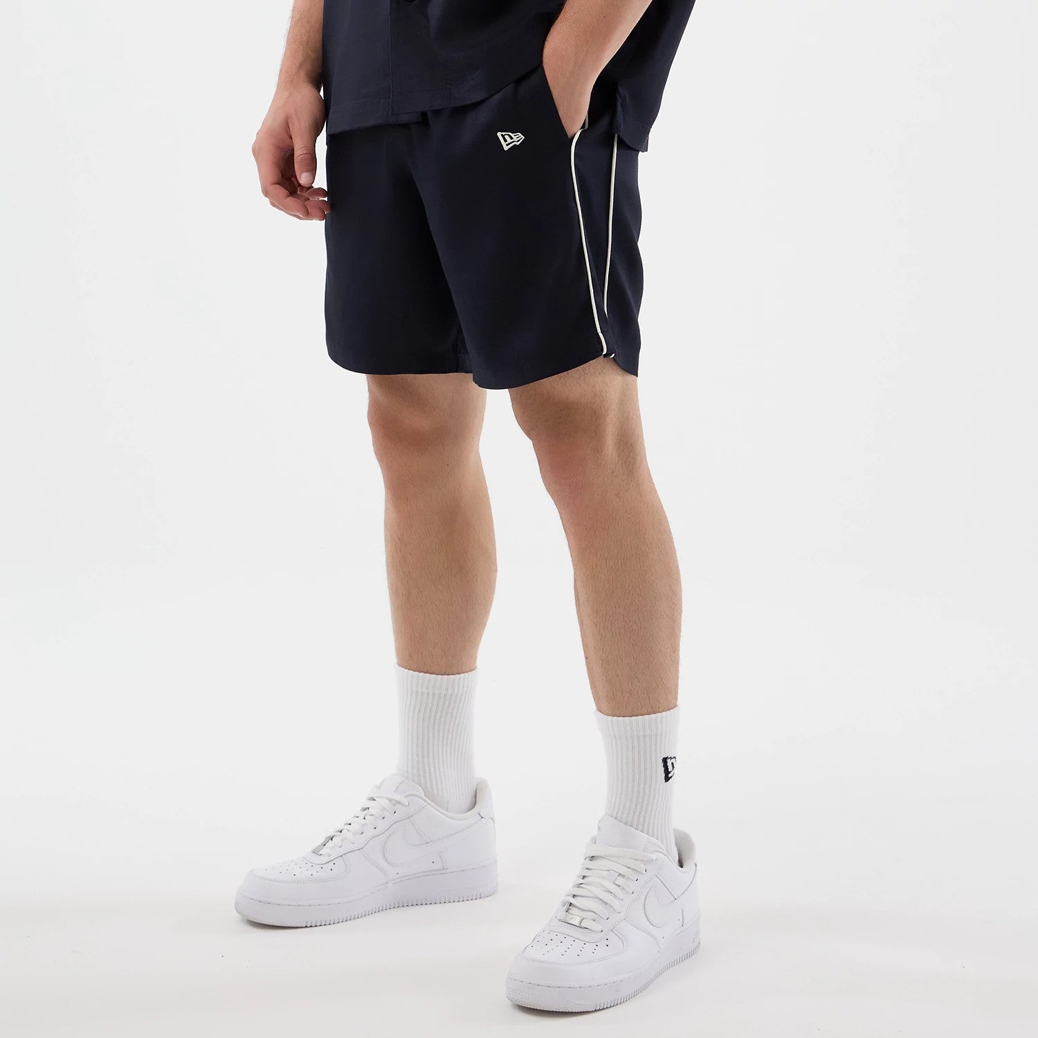 The model is wearing this New Era Piping Shorts in navy. 3