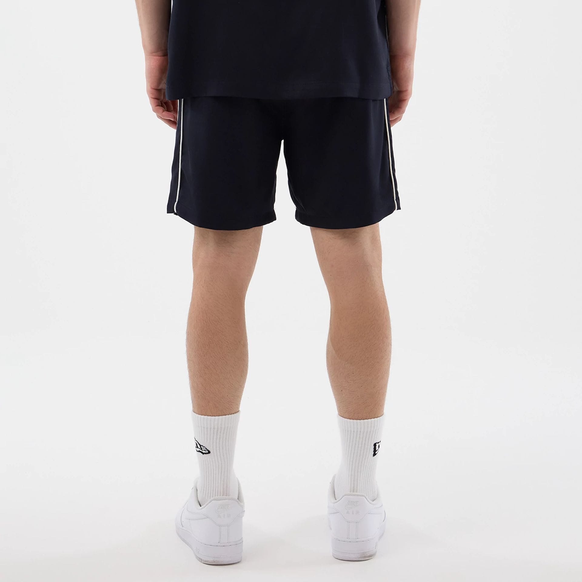 The model is wearing this New Era Piping Shorts in navy. 2