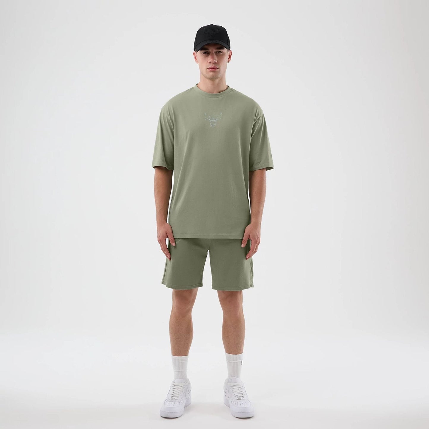 New Era Chicago Bulls NBA League Essential Pastel Green Oversized T-Shirt, front view on a model paired with shorts, featuring a printed Chicago Bulls logo in the centre of the chest, short sleeves, and a relaxed oversized fit.