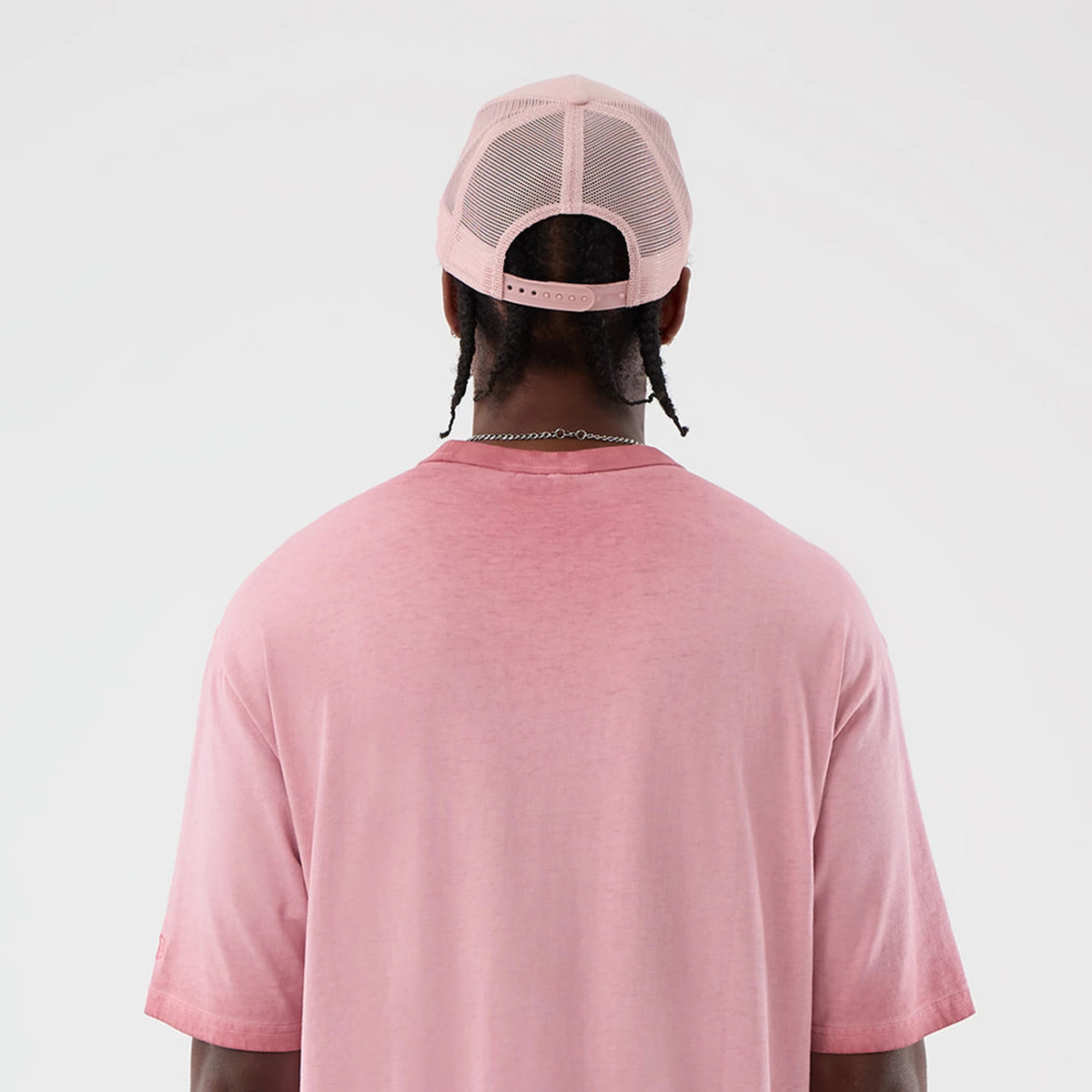 New Era New York Yankees MLB Washed Logo Pastel Pink T-Shirt, back view on a model wearing a pastel pink mesh cap, showing the plain pink back of the t-shirt with short sleeves and a relaxed fit.