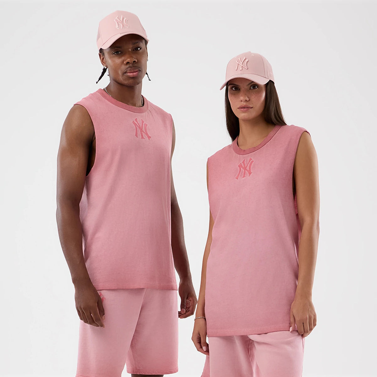 New Era New York Yankees MLB Washed Logo Pastel Pink Vest, on-model view showing the sleeveless design with a pink Yankees logo on the chest, paired with matching pastel pink shorts and cap featuring the same Yankees logo embroidering.