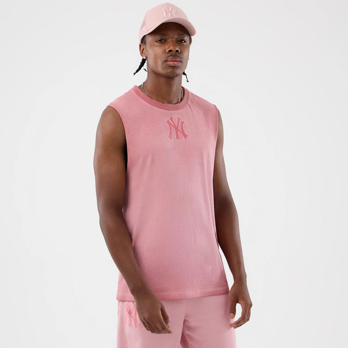 New Era New York Yankees MLB Washed Logo Pastel Pink Vest, front view on a model with a matching pastel pink cap, featuring a central embroidered NY logo in a slightly darker shade, sleeveless design and a relaxed fit.