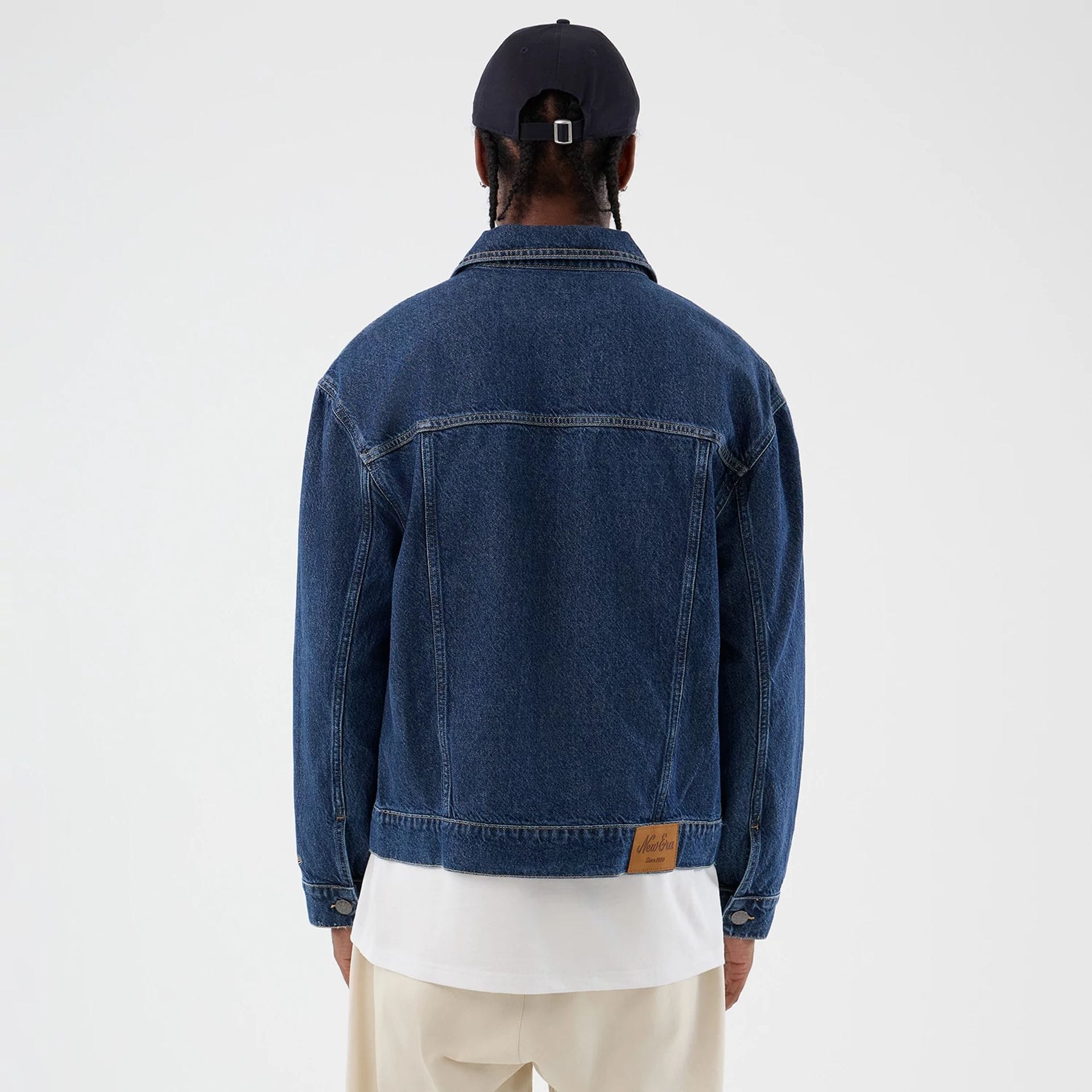 The model is wearing this New Era Script Denim Jacket in dark blue. 2